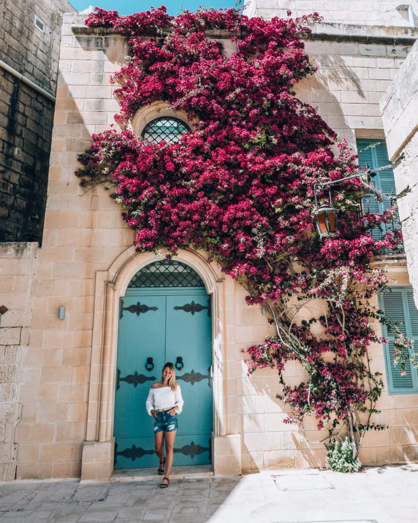 girl in doorway surrounded by flowers