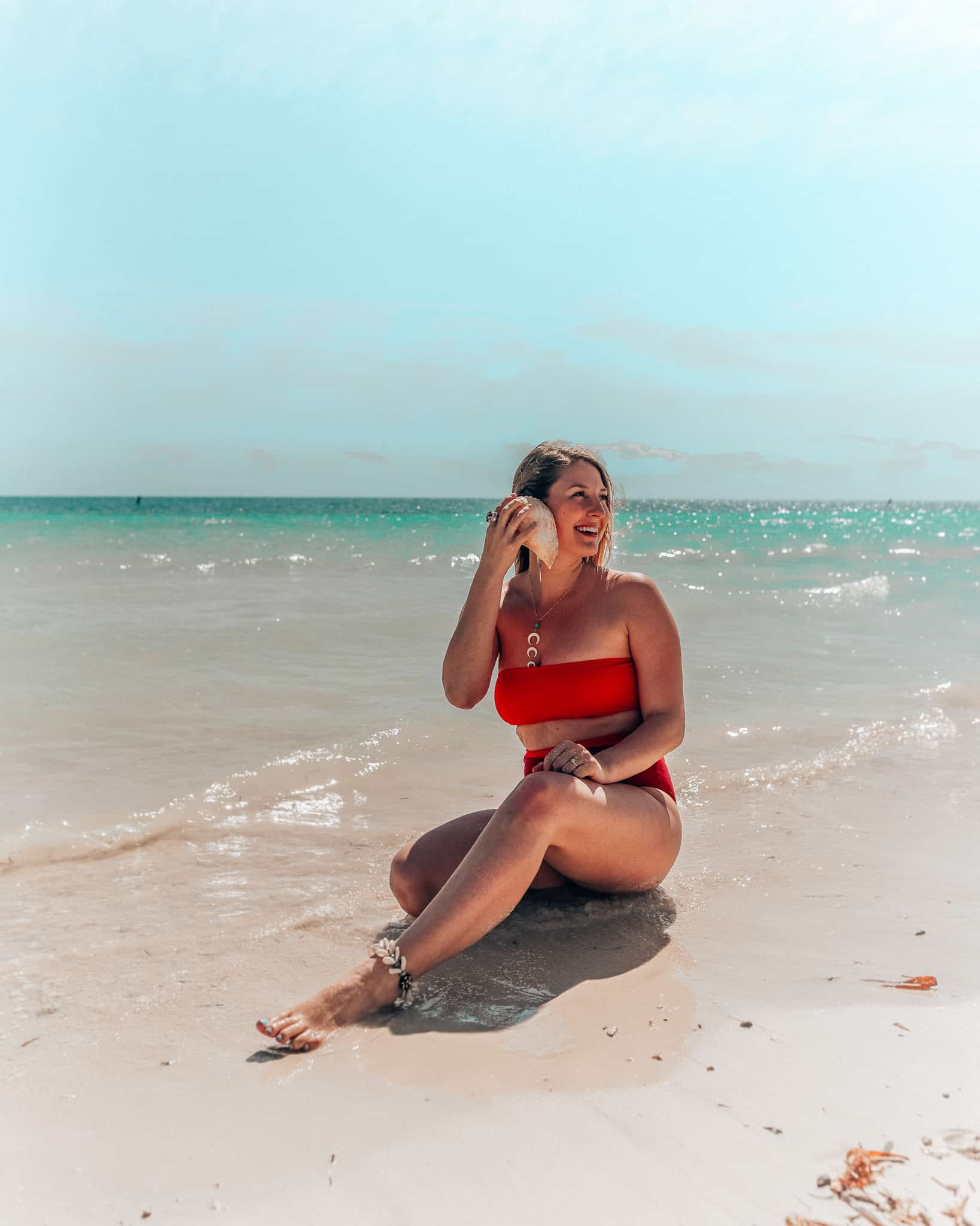 girl on beach holding shell