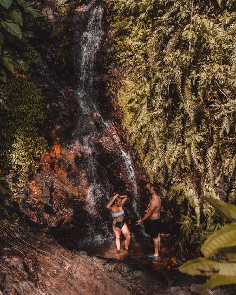 couple standing in waterfall