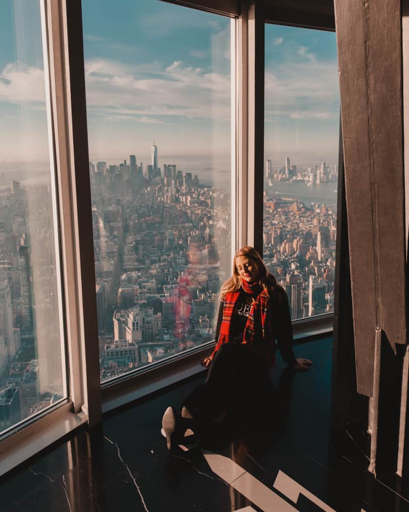 girl sitting in top floor of building with a view