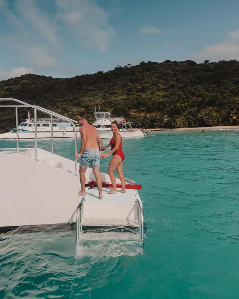couple standing on edge of catamaran