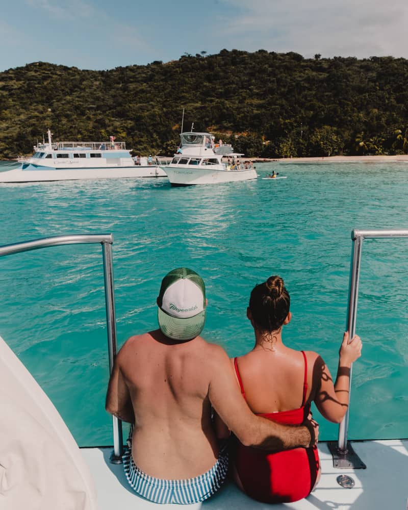 couple sitting on edge of catamaran