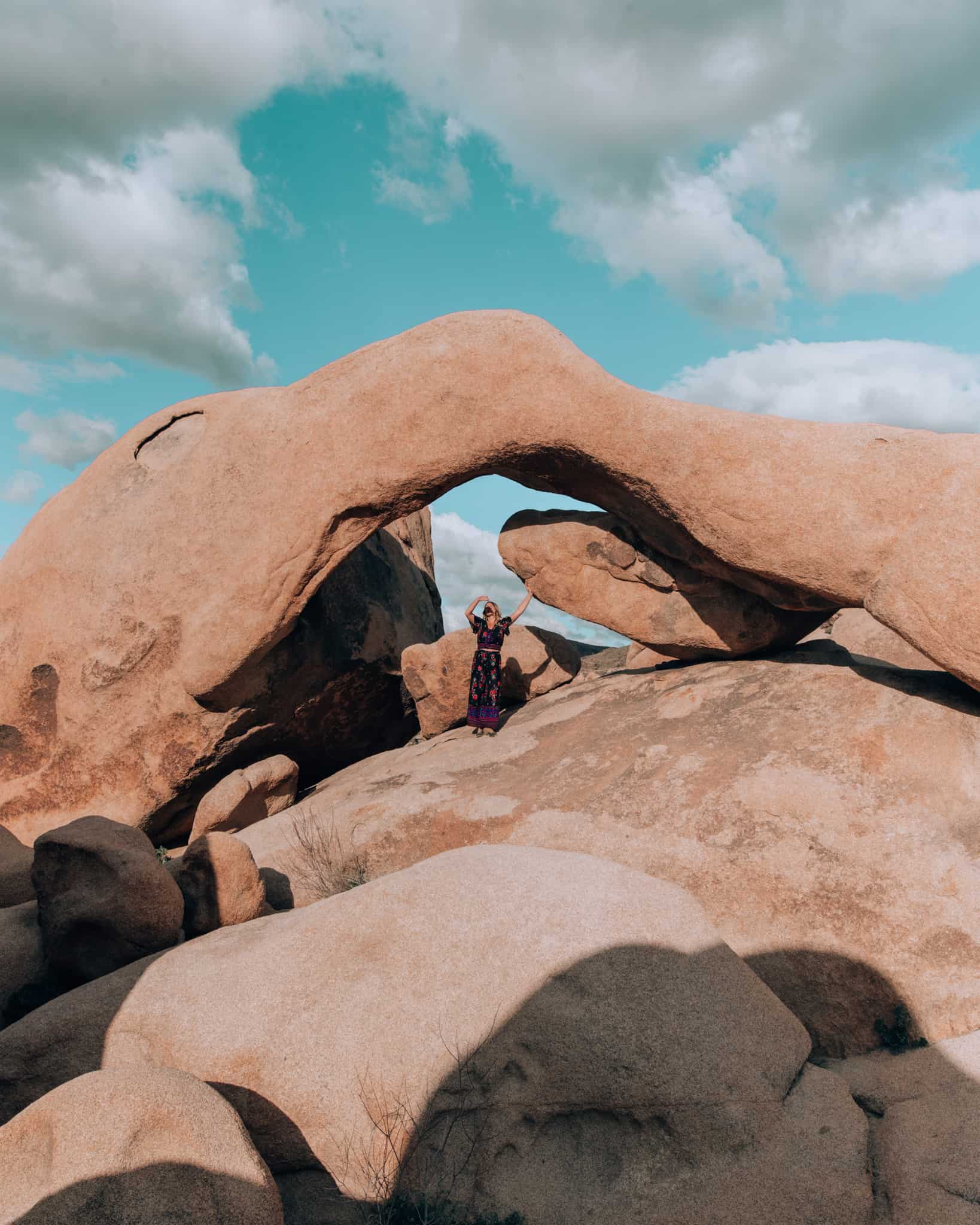 girl standing in front of arch rock