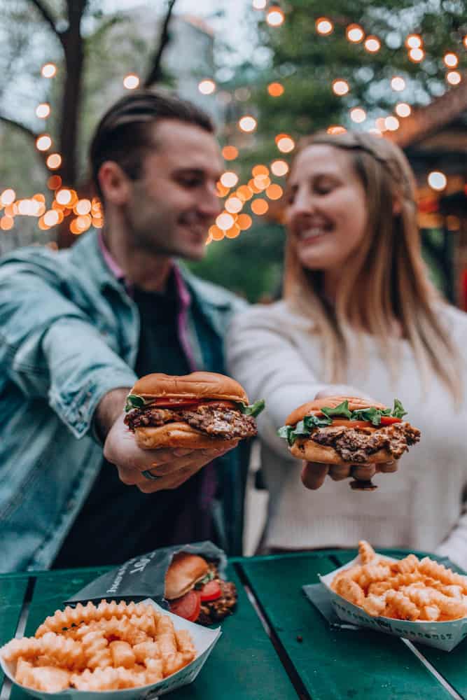 a couple holding up burgers