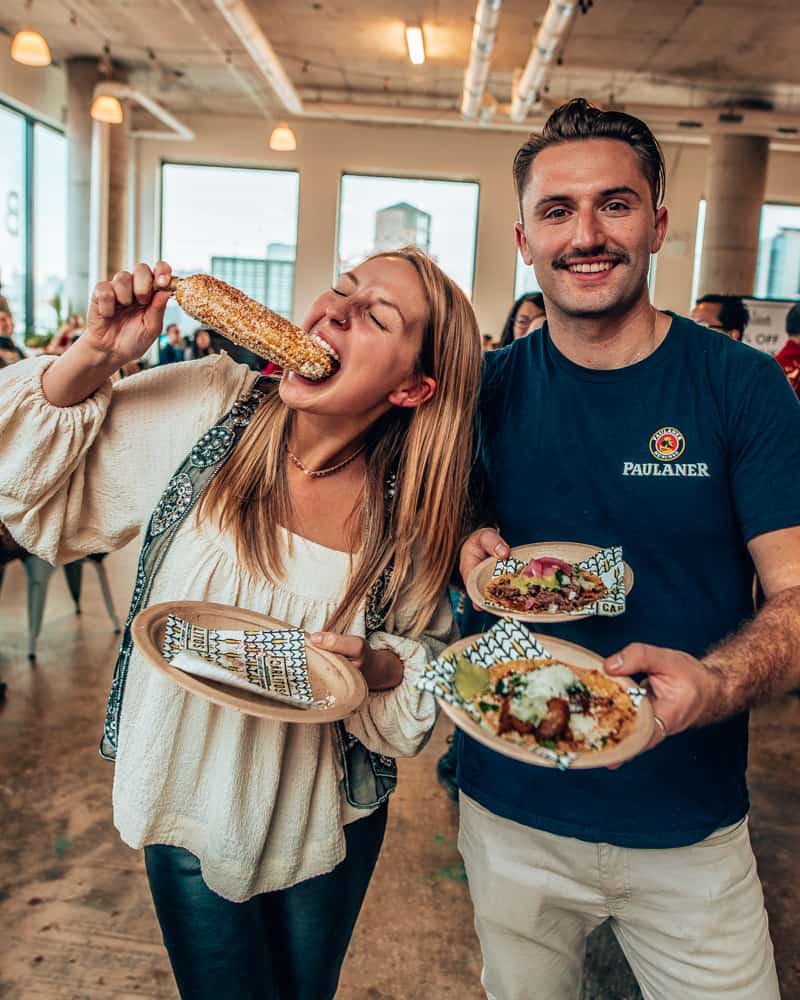 a couple standing easting Mexican food