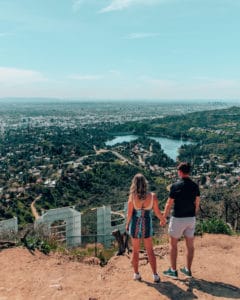 Couple standing behind the Hollywood Sign