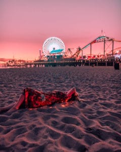 girl laying on beach in front of Santa Monica Pier