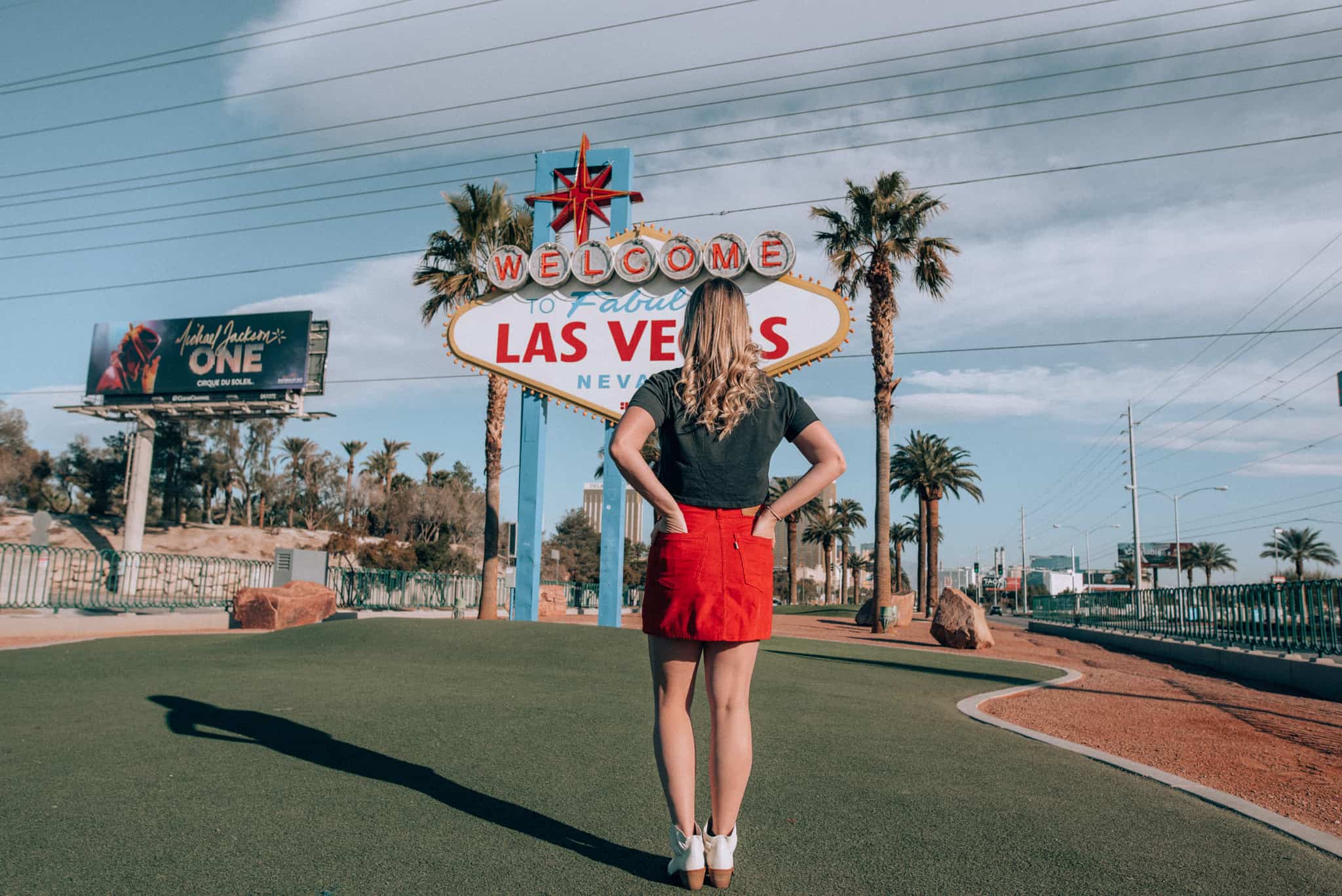 standing facing "welcome to Las Vegas" sign