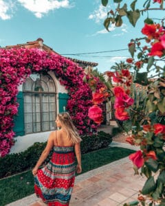 Girl standing next to pink rose bush