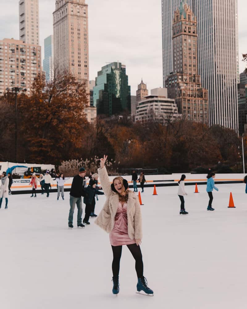girl standing on skating rink holding up peace sign