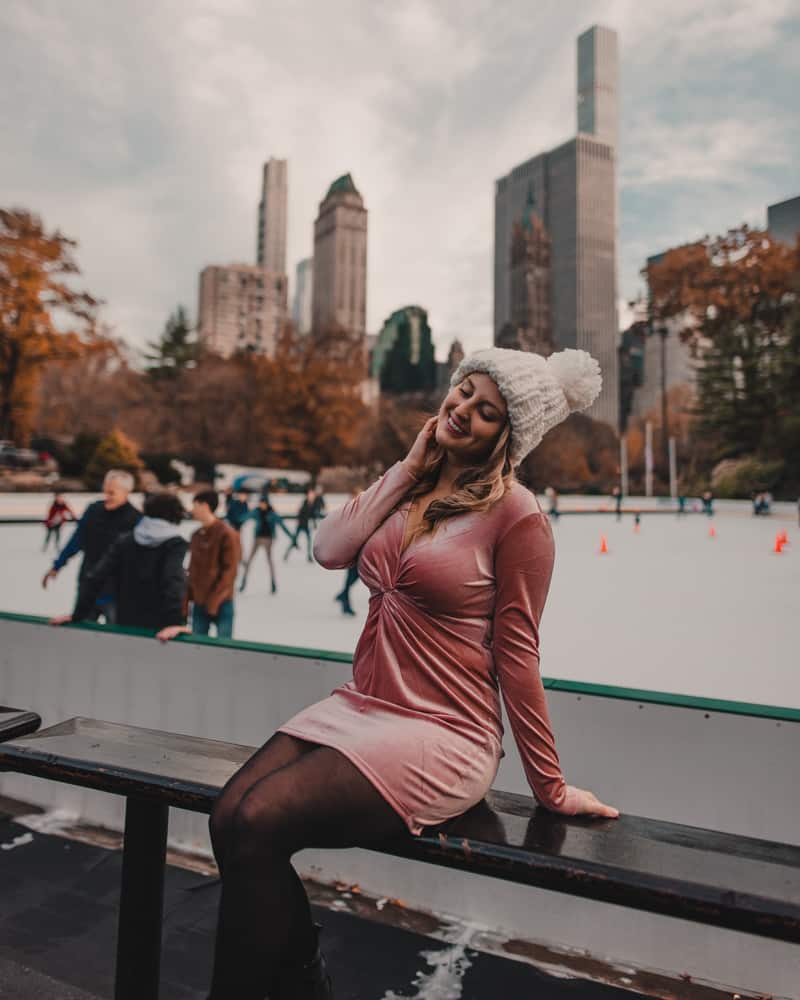 girl sitting in front of ice skating rink